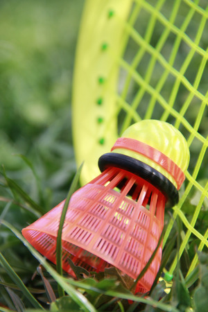 Close up badminton racket and shuttlecock laying on the green grassの写真素材