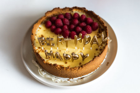 cheesecake birthday cake with raspberries and candles. High quality photo isolatedの写真素材