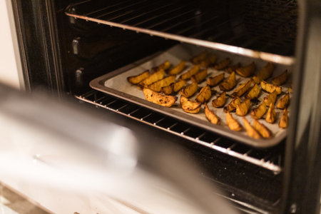 Baked potato wedges golden brown on parchment paper coming out of the oven high quality photoの写真素材