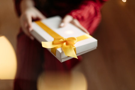 girl in red pajamas holding christmas present in white boxの写真素材