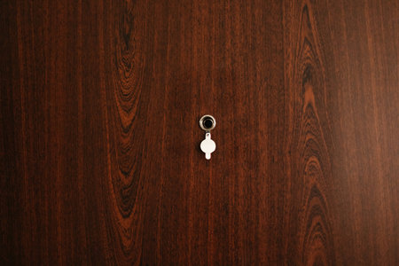 Through a peephole in the brown door of an apartment or house