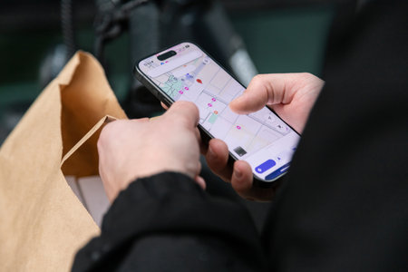 courier on a bicycle courier on a bicycle looks at the map on his phone and looks for an address to deliver an orderの写真素材