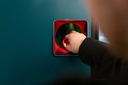 Man hand puts plastic bottle to the machine. Shoppers return their bottles and cans.