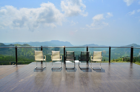 Magnificent outdoor terrace with chairs on sunny terrace with bay view and decoration in contemporary home.の写真素材