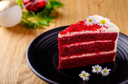 Red velvet cake on black color plate put on wooden table.の写真素材