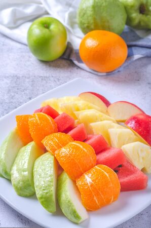 Mix healthy fresh fruits on white plate.の写真素材