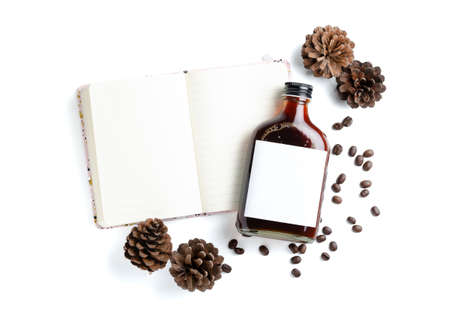 Iced cold brew coffee in blank label bottle on white notebook and decorated side with roasted coffee...