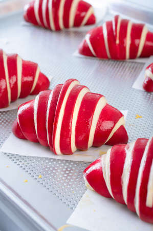 Close up on raw raspberry croissants before baking on tray. Classic French pastry.の写真素材