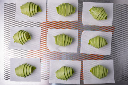 Raw green tea croissant dough with green tea filling before baking on tray.の写真素材