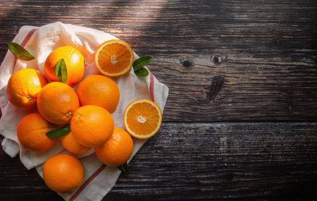 Fresh orange fruits with leaves on wooden table and sunlight morning.の写真素材