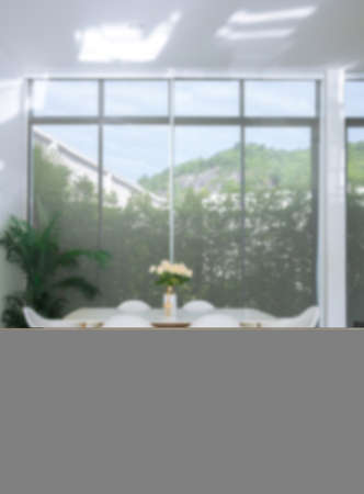 The white dining room is spacious and bright with large white tables, blurred background.の写真素材
