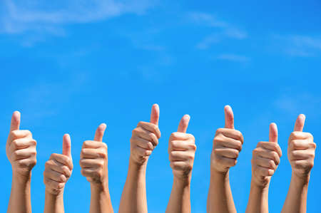 Many Human hands with thumb up in the clear blue sky. Gesture and body parts concept, OK, good,...