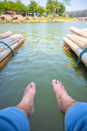 Feet immersed in the water on the raft, Feet in water. Selfie of legs and barefoot. Vacation at summer holiday.の写真素材