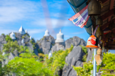 Ceramic Chicken bells hanging on top of the mountain in Wat Phaphutthabat Phuphadaeng, There is a white pagoda built on a high rocky mountain by belief and faith. Chae Hom district, Lampang, Thailand.の写真素材