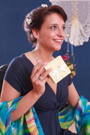 Elegant woman in evening dress with a gift in handの写真素材