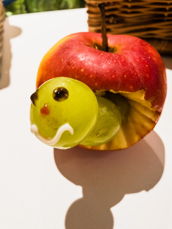 Apple with a worm of grapesの写真素材