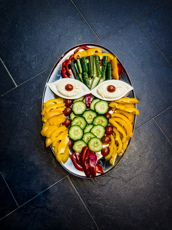 Salad plate with various salads on silver tray and stone floor as backgroundの写真素材