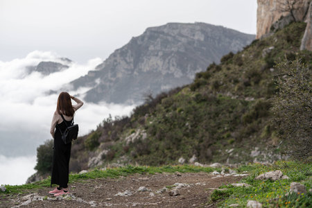 Young asian girl enjoy the beautiful landscape scenery with clouds while hiking along the mountain trail located at Positano, Italy.の写真素材
