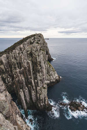 Ultra wide angle scenery of cliff by ocean against clear sky at Cape Hauy, Tasman National Park, Tasmaniaの写真素材