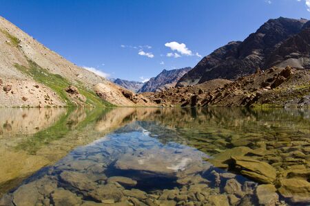 Mountain lake  with the beautiful reflections in water of the surrounding nature and blue skyの写真素材