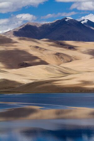 Tsomoriri mountain lake panorama with mountains and blue sky reflections in the lake (north India)の写真素材