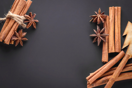 Frame with cinnamon sticks and star anise on a dark background. Top view, copy space.の写真素材