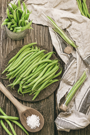 Bunch of freshly picked green beans on a rustic wooden surface. flat layの写真素材