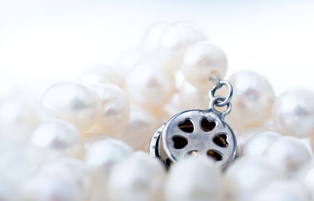 Closeup of natural freshwater pearl necklace and a metal clasp, shallow focus
