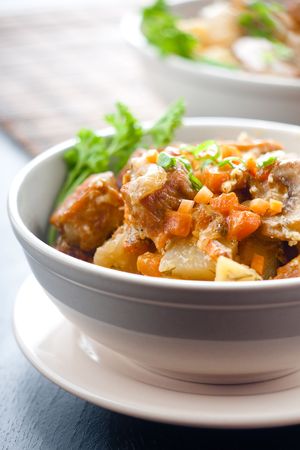 Pork stew with potatoes and mushrooms in a ceramic bowlの写真素材