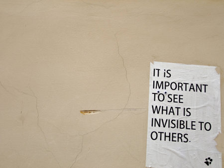 Note saying that it is important to see what is invisible to others on the Wall of old Buildingの写真素材