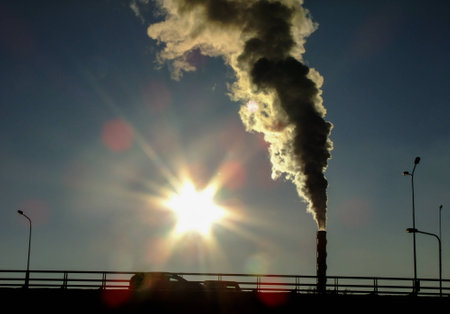 High Chimney emits a large amount of Smoke in Vilnius City, Lithuania during the Sunsetの写真素材