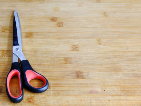 Big Scissors on left Side of wooden Cutting Boardの写真素材