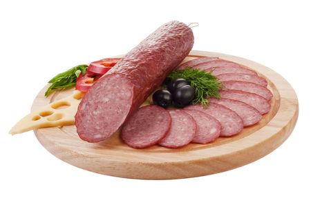 Sliced sausage with vegetables on a wooden plate isolatedの写真素材