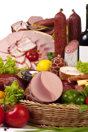 A composition of meat and vegetables with a bottle of wine isolated on whiteの写真素材
