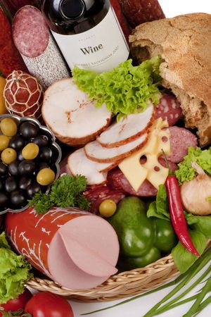 A composition of meat and vegetables with a bottle of wine isolated on whiteの写真素材