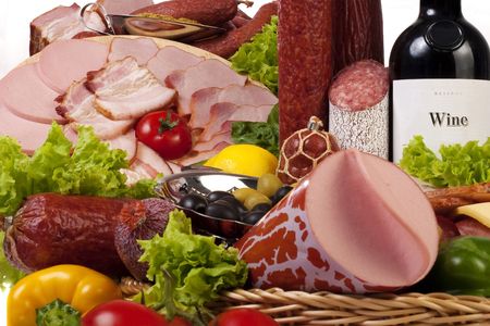 A composition of meat and vegetables with a bottle of wine isolated on whiteの写真素材