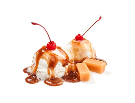 Two icecream balls under the caramel topping with cherry on the topの写真素材