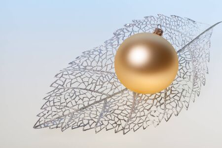 New Year background with golden glass toy on silver decorative leafの写真素材