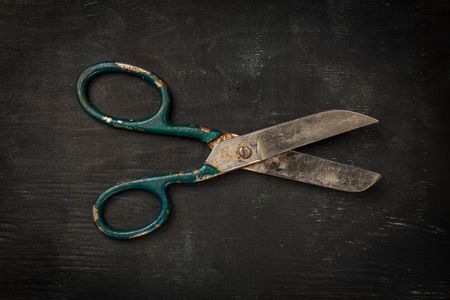 Vintage scissors on black wooden background