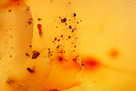 Natural amber texture. Yellow opaque natural amber with layers.