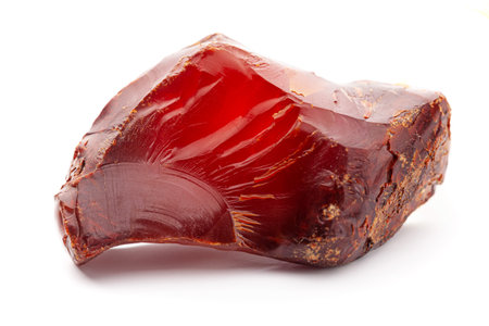 A piece of yellow opaque natural amber classification color cherry or dragon blood, has superficial cracks on its surface. Polished. Placed on white background.の写真素材