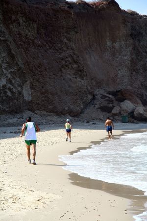 people running on the sea shoreの写真素材