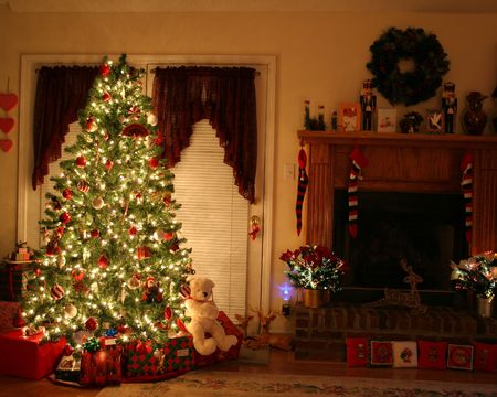 Home with lighted christmas tree, presents,fireplace,stockingsの写真素材