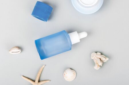 Anti pollution drops and daily care creams with dropper and seashells. Flat layの写真素材
