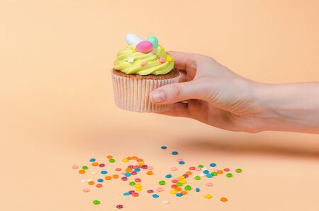 Row of bright pistachio Easter cupcake with decorations in hand close up