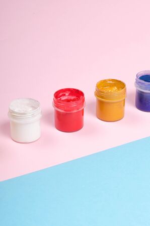 Bottles with paint on bright pink and blue background