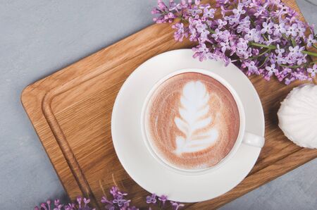 Lilac, coffee with latte art on gray wooden table. Romantic morning. Flat layの写真素材