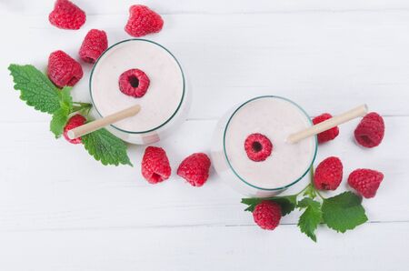 Two glasses of raspberry milkshake on wooden backgroundの写真素材