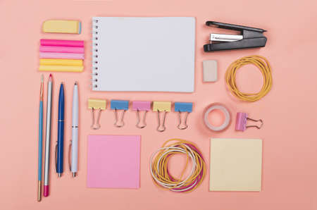 Different school supplies on light pink background