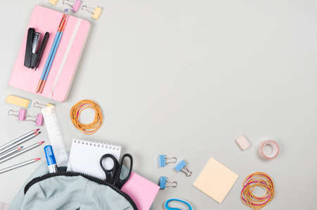 Different school supplies on  grey